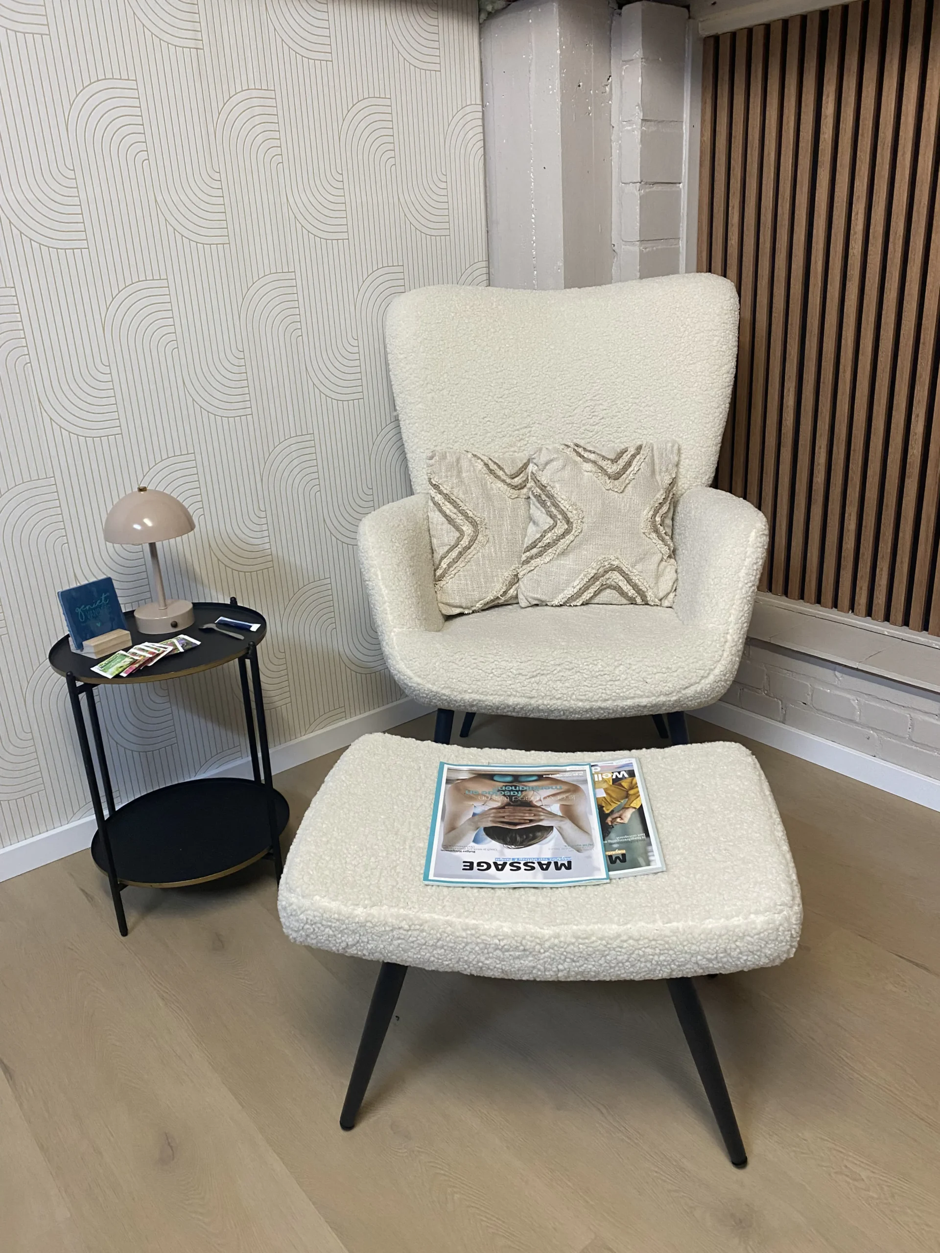 Loungehoek met fauteuil en hocker bij Jenn Massage